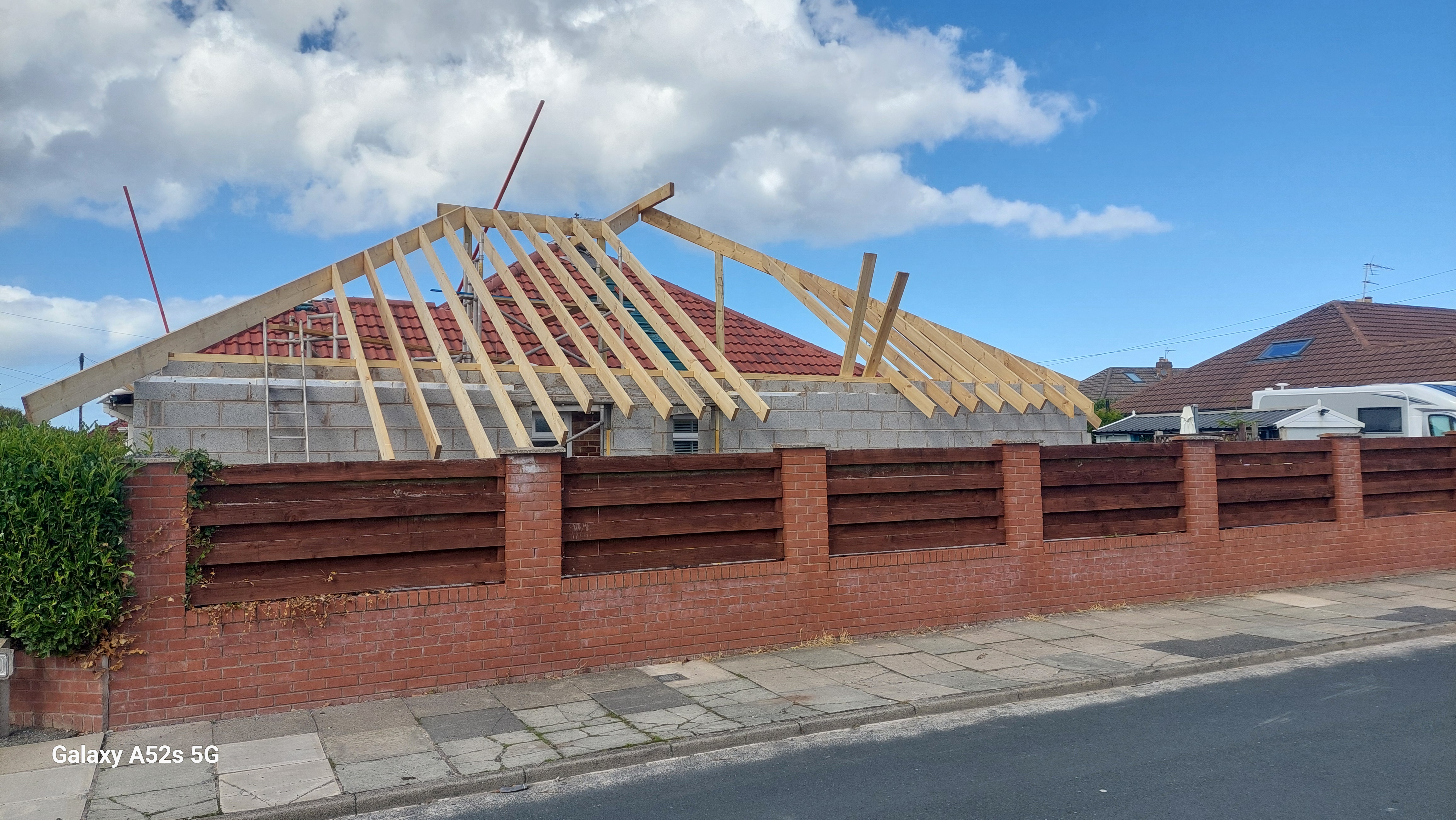 Progressing structural timber roof framework on brick extension